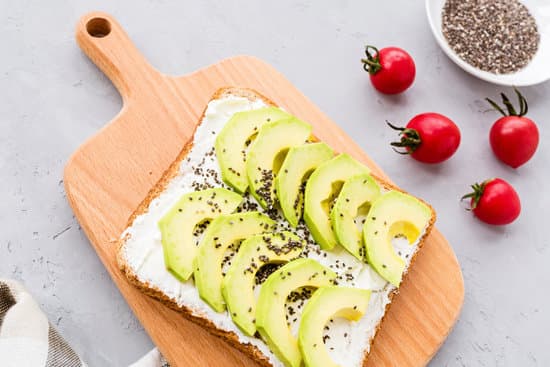 canva toast with avocado slices on a wooden board