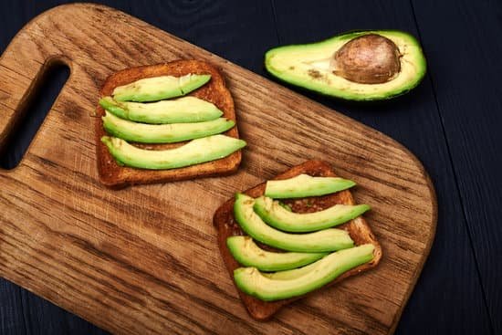 canva toast with sliced avocado on a wooden background MAEAp8p JK0