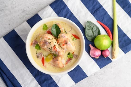 canva tom kha kai in a bowl with kaffir lime leaves lemongrass red o