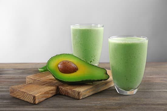 canva two glasses of avocado smoothie on wooden cutting board MAD QoBTl1s