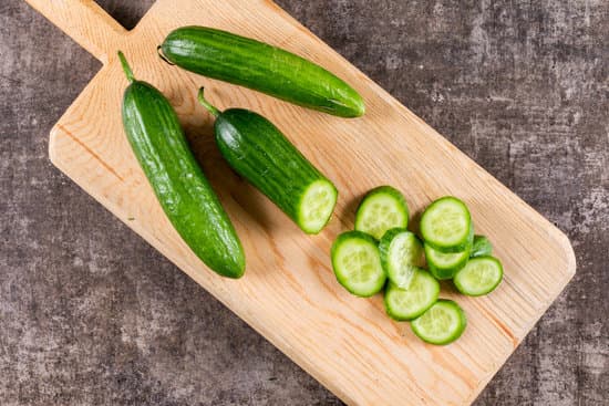 canva whole and sliced cucumbers on wooden cutting board MAD gSFtgy8