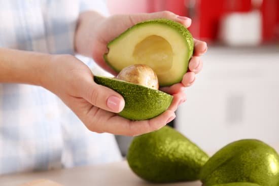 canva woman holding fresh avocado in kitchen MAD QkuGSnc