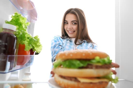 canva woman looking at a burger in the fridge MAD QyCd3HY