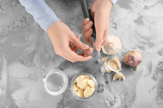 canva woman peeling garlic with a knife on table MAD76pKdKKA