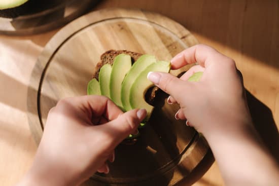 canva woman putting sliced avocado on rye bread MAERFQHncDA