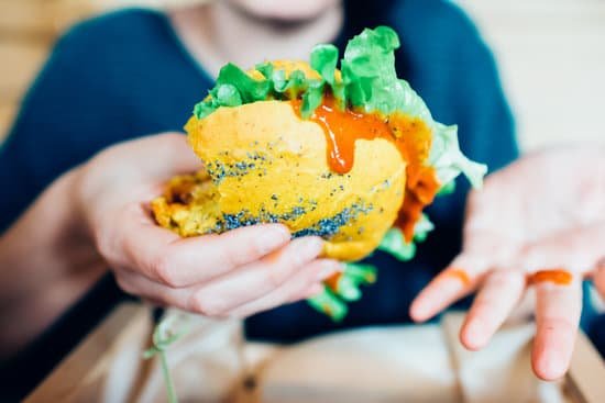 canva woman sitting holding a vegan burger MABoiwyf 5c