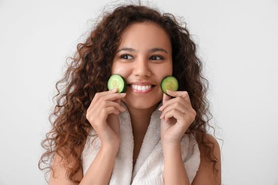 canva woman with curly long hair holding cucumber slices MAD7pP6tKz4