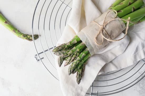 canva wrapped and tied fresh green asparagus on cooling rack
