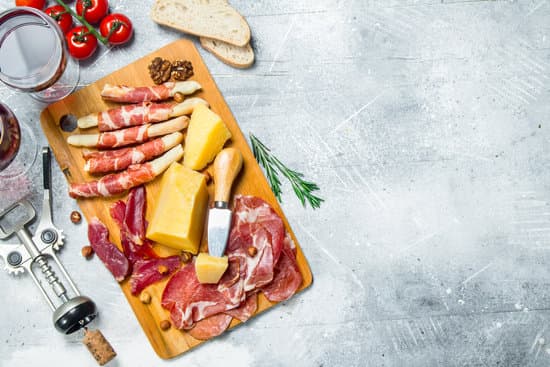 canva antipasto background. various meat and cheese snacks with red wine. MAEQLWvKfdM