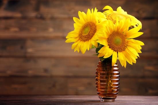 canva beautiful bright sunflowers in a vase on wooden background MAD Mr73lV0