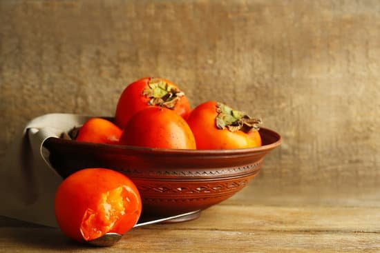 canva bowl of persimmons on a wooden table MAD L2RIWy0