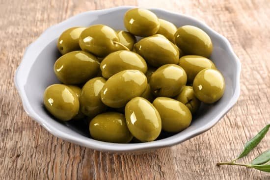canva bowl with olives on wooden table MAD9T9h5aWw