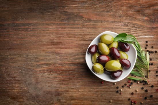 canva bowl with olives on wooden table MAD9T tU2X0