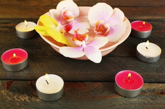 canva bowl with orchids and candles on wooden background MAD MMn8UyI