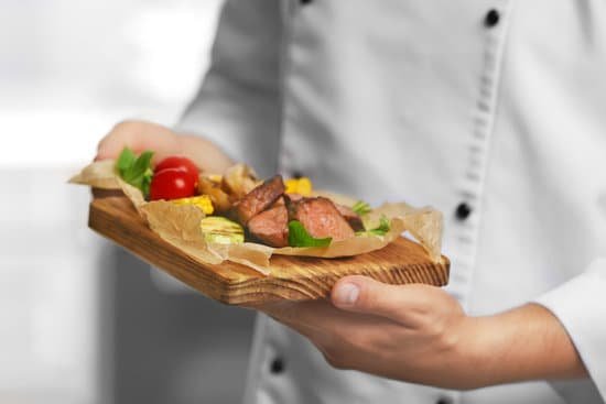 canva chef holding a wooden board with meat and vegetables MAD9T7gTeKM