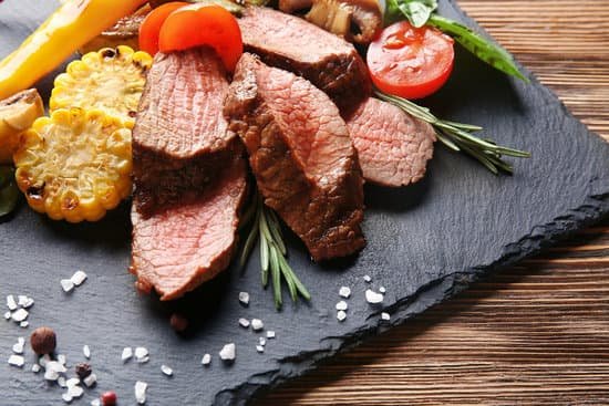 canva cooked juicy meat with vegetables on a slate plate MAD9T2p6QG8