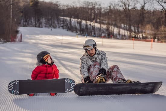 canva dad teaches son snowboarding in winter MAELBVJuLX4
