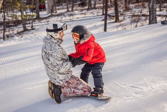 canva dad teaches son snowboarding in winter MAELBZSFecg