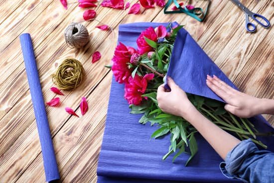 canva female florist making bouquet of peonies in flower shop MAD9bRZBHGg