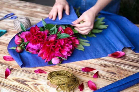 canva florist making bouquet of peonies in flower shop MAD9bZ4YyF0