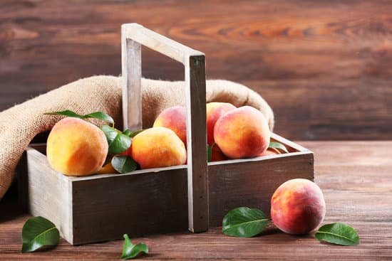 canva fresh peaches in crate with sackcloth on wooden background MAD MsEwDaM