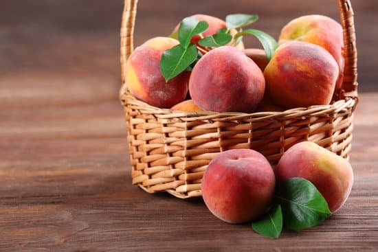 canva fresh peaches in wicker basket on wooden background MAD MoIhKYI