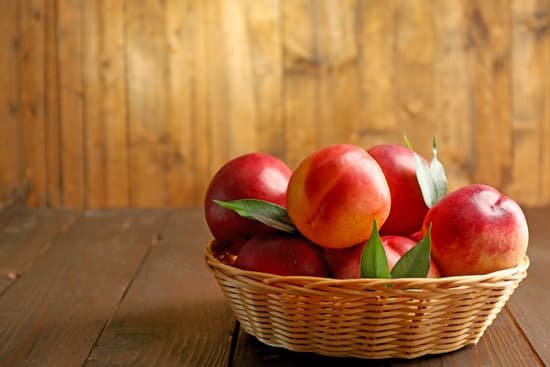 canva fresh peaches in wicker basket on wooden background MAD Ms8b5q0