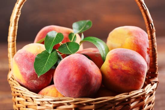 canva fresh peaches in wicker basket on wooden table close up MAD MrdR W4