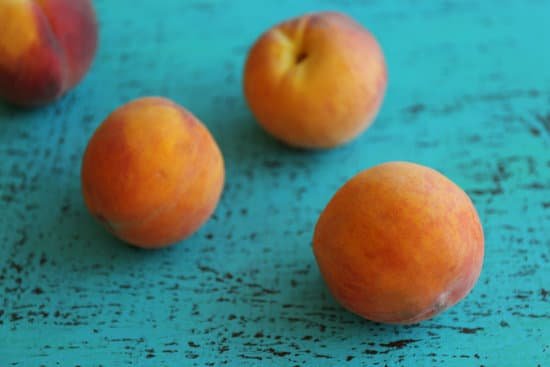 canva fresh peaches on a blue wooden background MAD Q66vsmw