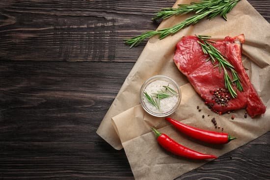 canva fresh raw meat with rosemary on wooden background MAD9Tz Yf7U