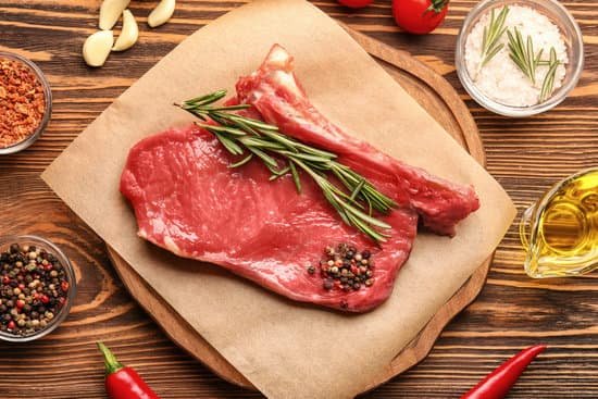 canva fresh raw meat with rosemary on wooden board MAD9Twj UWY