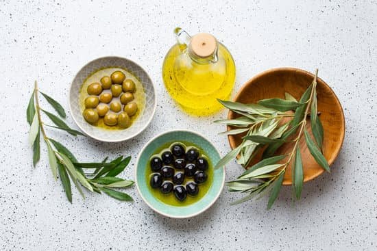 canva green and black olives with bottle of oil and leaves MAEKEaI7jQs
