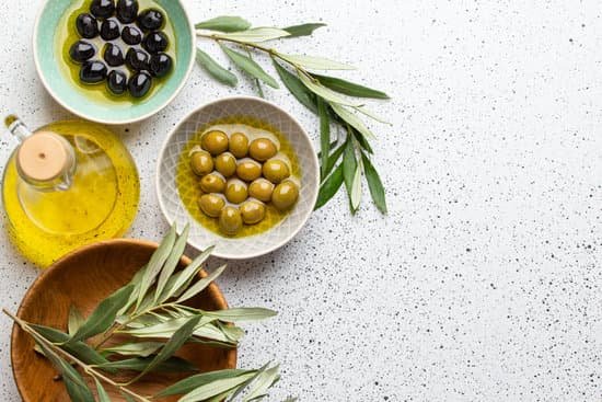 canva green and black olives with olive oil on white surface MAEKEVlOXvk