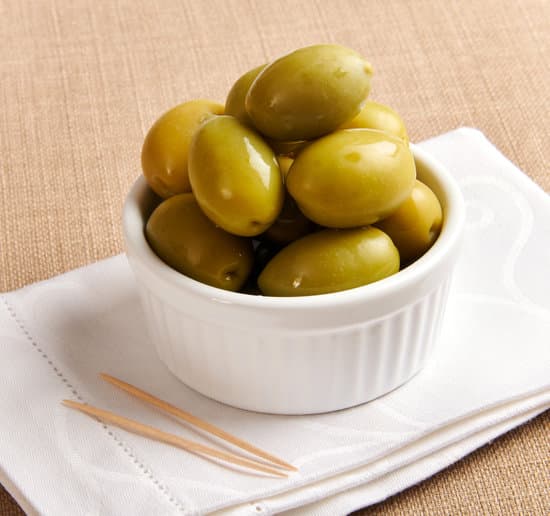 canva green olives in a ramekin on tissue with toothpicks MAEOs2EJW E
