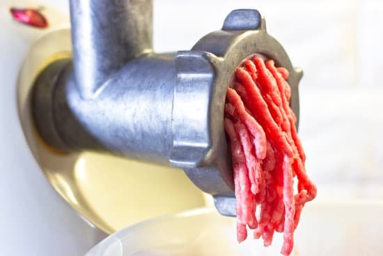 canva grinding red meat in mincer machine on white background MAD60fMzefg
