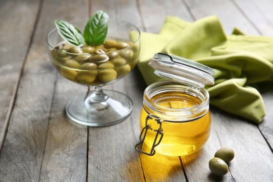 canva jar with cooking oil and olives on wooden table MAD9T5YyEmQ