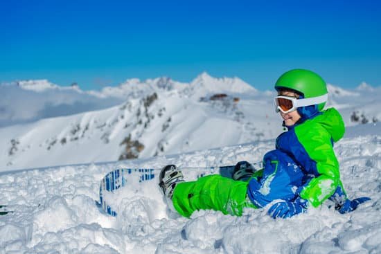 canva little boy sitting on snow with snowboard MAD ggvOZwE