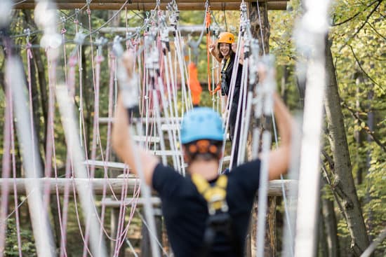 canva man and woman climbing ropes in the adventure park MAEOxrAKM k