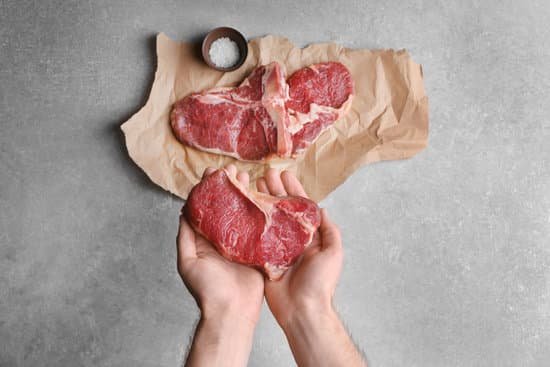 canva man holding meat steak on kitchen MAD QzQeogI