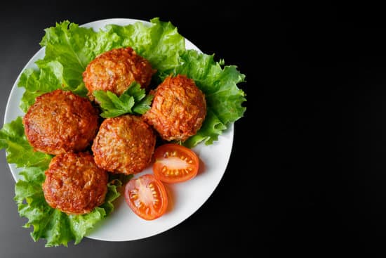 canva meat balls with lettuce in a plate on black background MAESpntGp8c