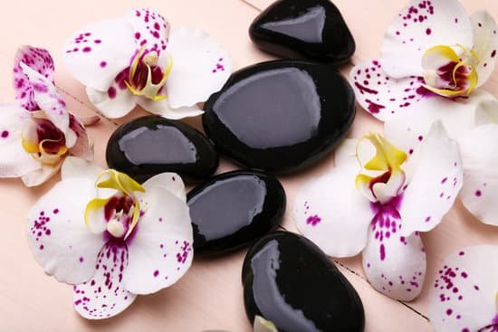 canva orchids and zen stones on wooden background MAD MhmrVoo
