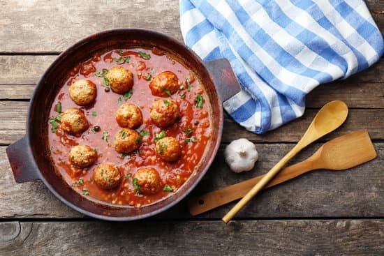 canva pan with meat balls in tomato sauce on wooden background MAD MdkMjCI