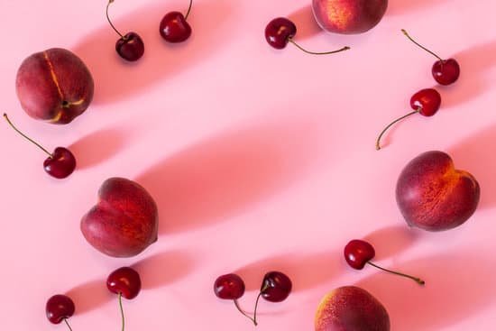 canva peaches and cherries on a table MAD l3pO9bE