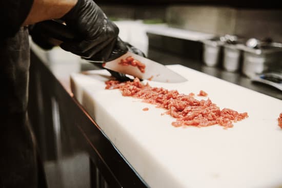 canva professional chef cutting raw meat with knife MAEQbgds ks