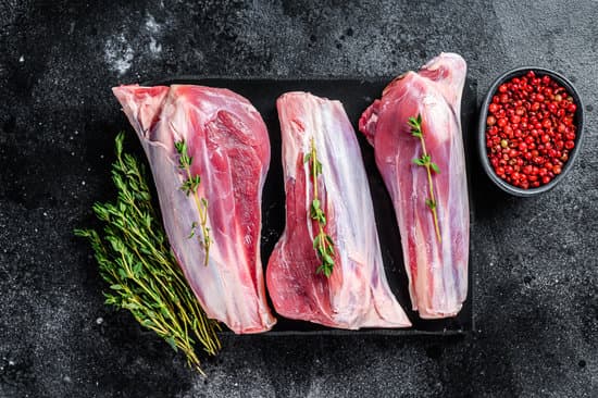 canva raw goat shanks meat on a marble board.