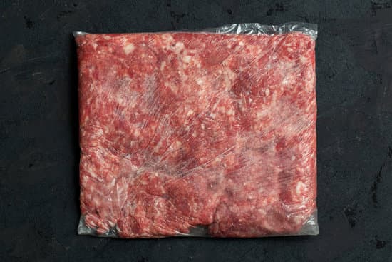 canva raw ground meat in transparent plastic package on dark background MAD70hP1474