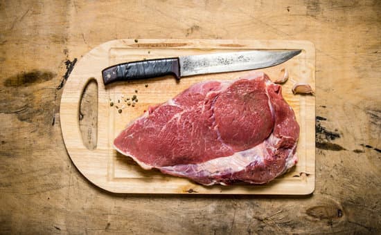 canva raw meat with knife on wooden board MAESmS8jra4