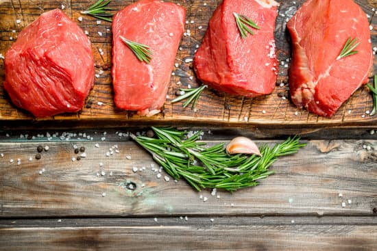 canva raw meat with rosemary and salt on wooden background MAEP iGjU9E