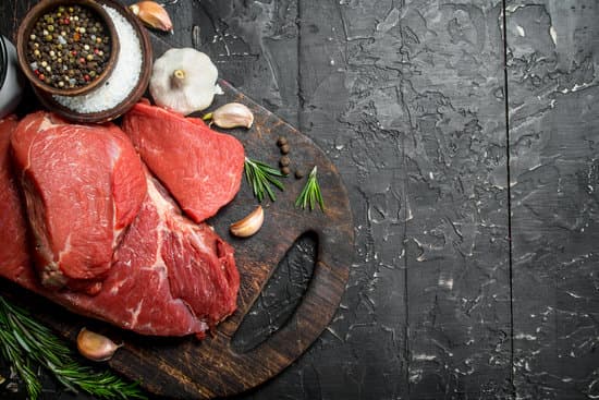 canva raw meat with spices and herbs on a wooden board MAEP2 KoKNk