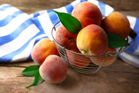 canva ripe peaches in metal basket on wooden background MAD MZpmW Y